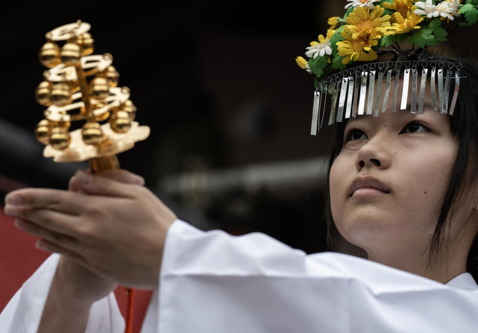 Une femme dirige une cérémonie avant le départ d'une procession lors du festival Kanamara à Kawasaki, près de Tokyo, le 5 avril 2026